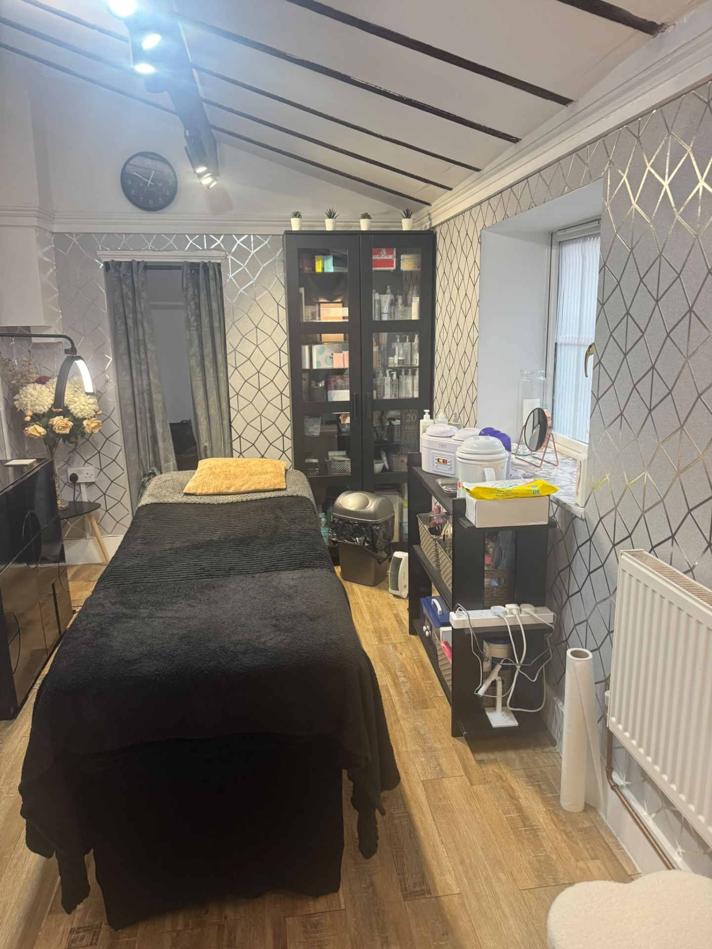 Treatment room with product shelves and massage bed